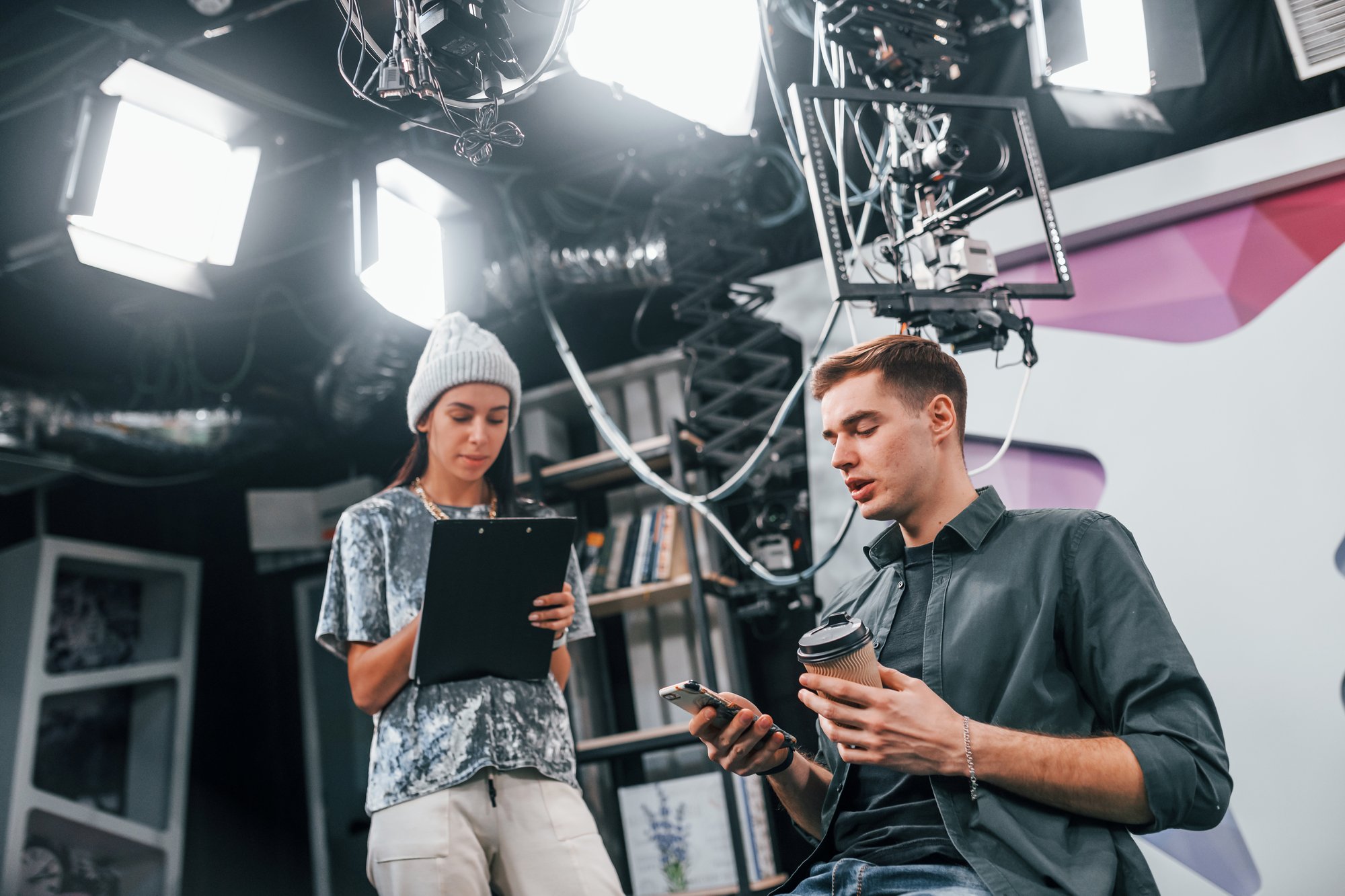 young-man-is-preparing-tv-online-broadcast-woman-helps-with-make-up